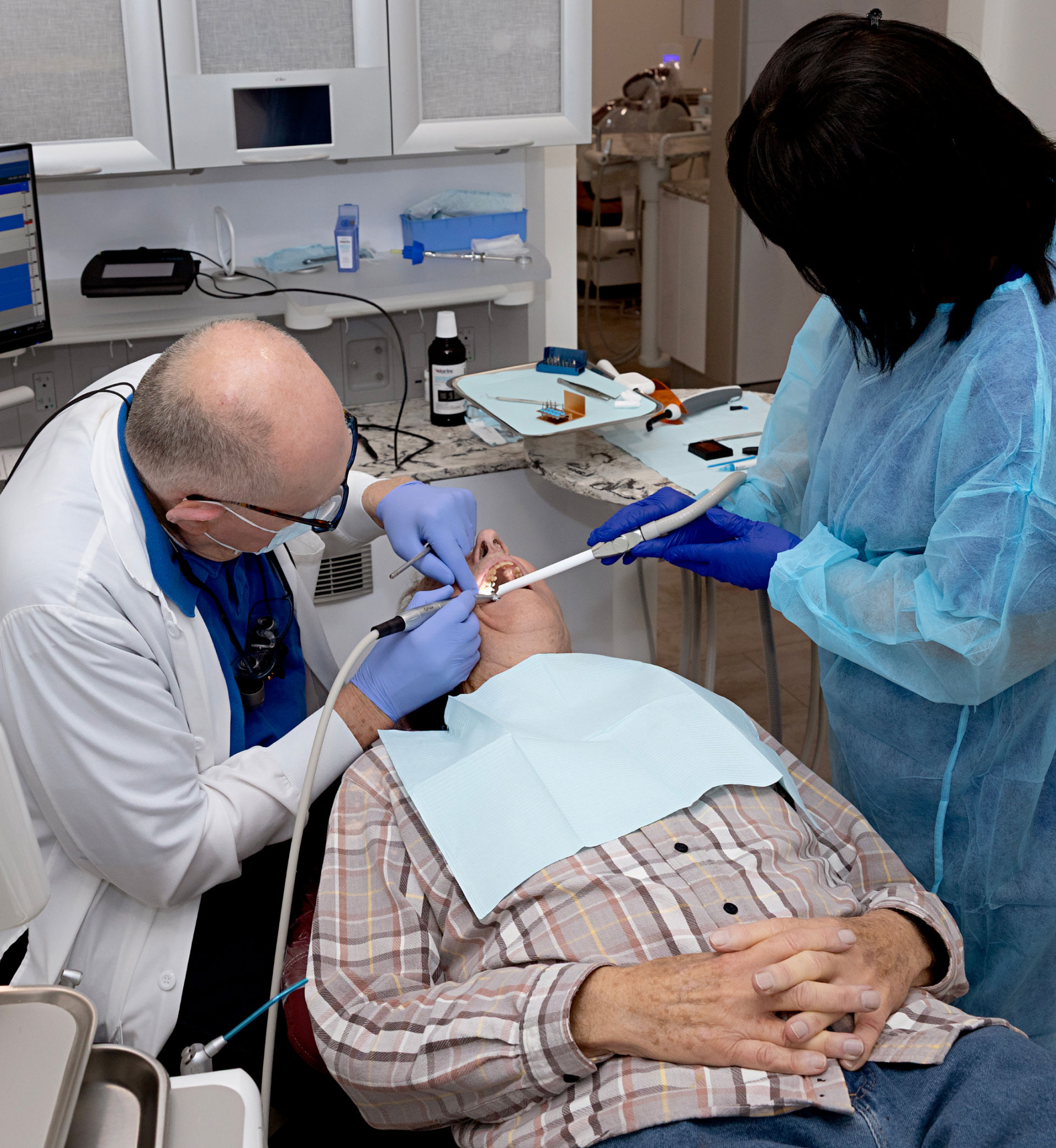 Dr. Flanagan and assistant performing dental exam on patient